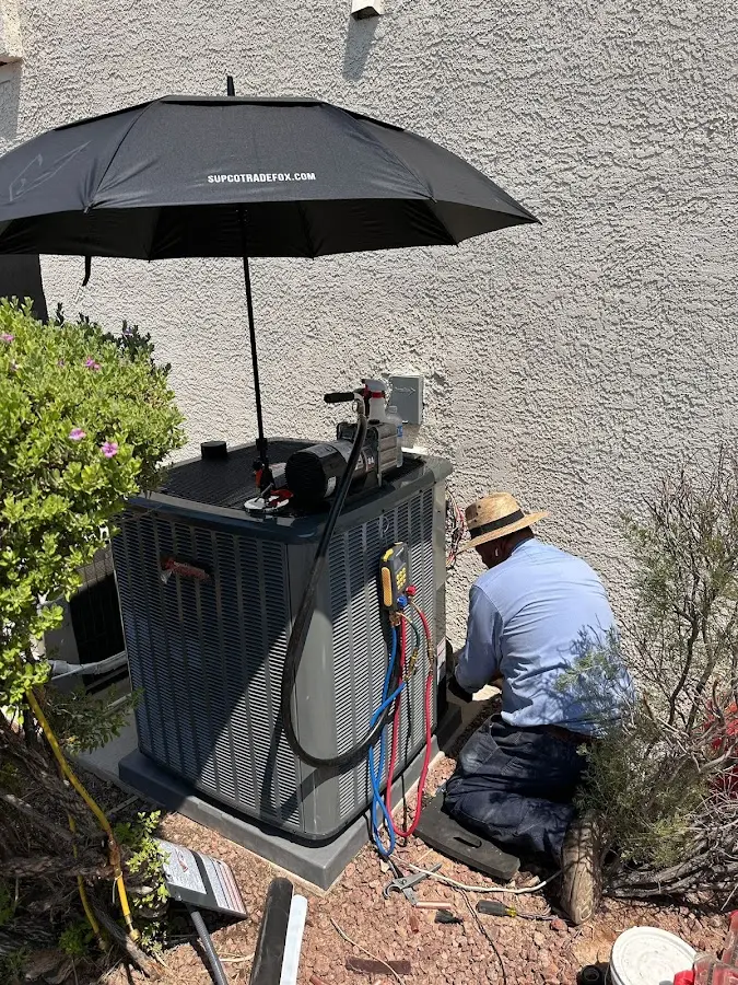 HVAC technician performing outdoor AC maintenance in Middlebury